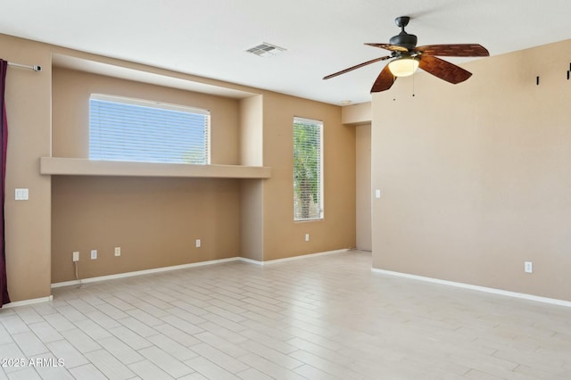 empty room featuring baseboards, ceiling fan, visible vents, and light wood finished floors