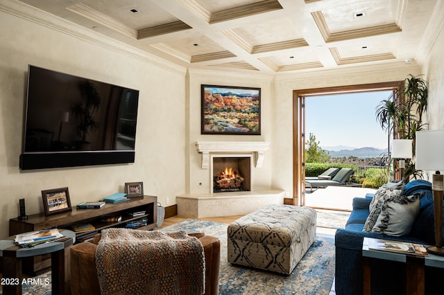 living room with coffered ceiling, a mountain view, a high end fireplace, hardwood / wood-style floors, and crown molding