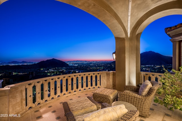 balcony at dusk featuring a mountain view