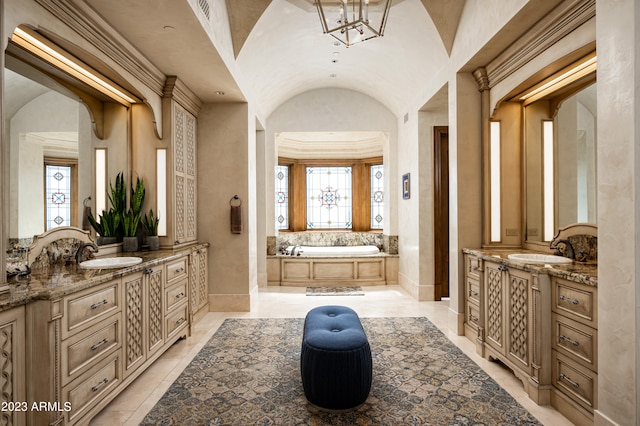 bathroom featuring vanity, vaulted ceiling, a tub to relax in, and plenty of natural light