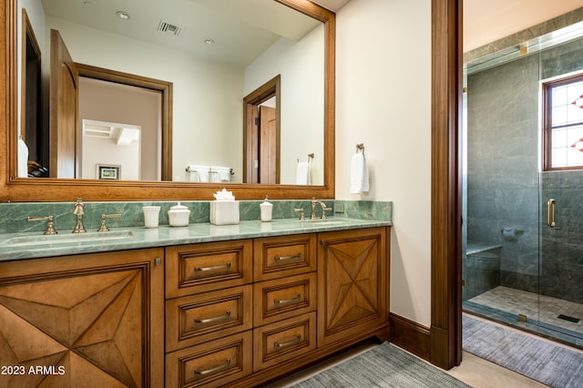 bathroom featuring a shower with door and vanity