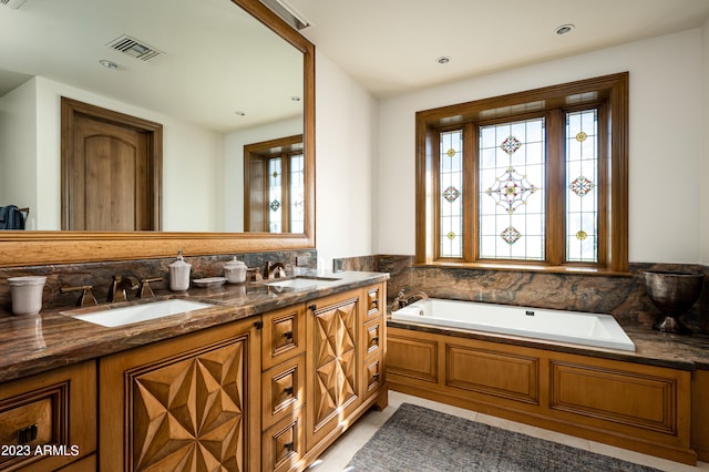 bathroom featuring vanity, a bath, and tile patterned flooring