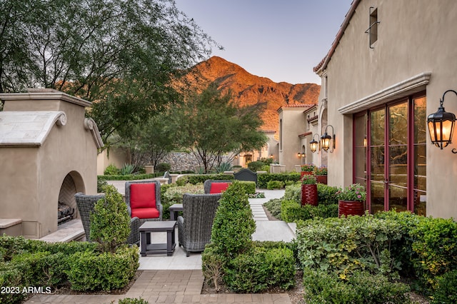 yard at dusk with a patio and a mountain view