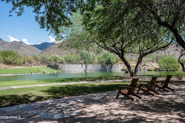 view of community featuring a water and mountain view and a lawn