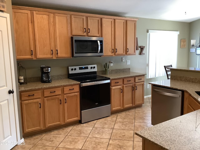 553 W Hereford Dr, San Tan Valley, AZ 85143 - kitchen featuring light tile patterned floors, light stone countertops, brown cabinetry, and stainless steel appliances