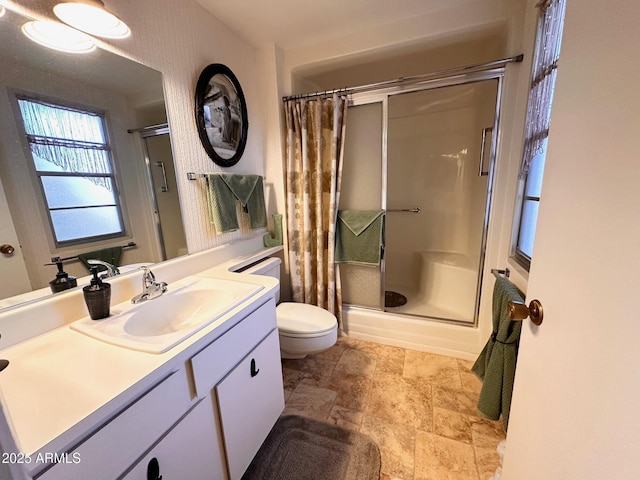 bathroom with an enclosed shower, vanity, and toilet