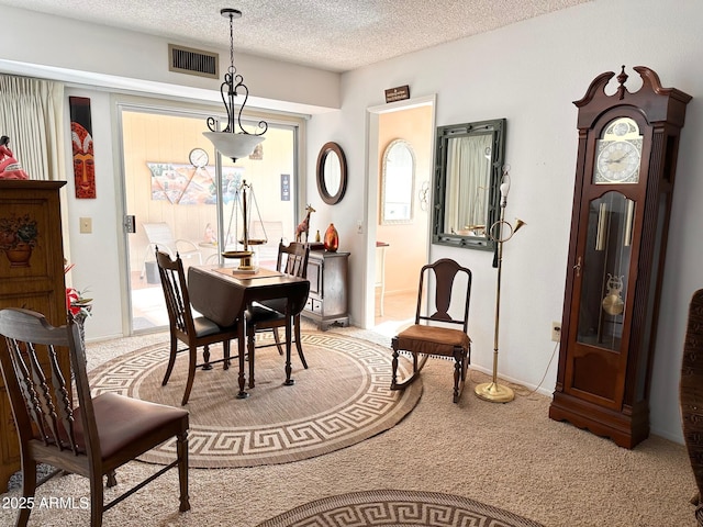 dining area with light carpet and a textured ceiling