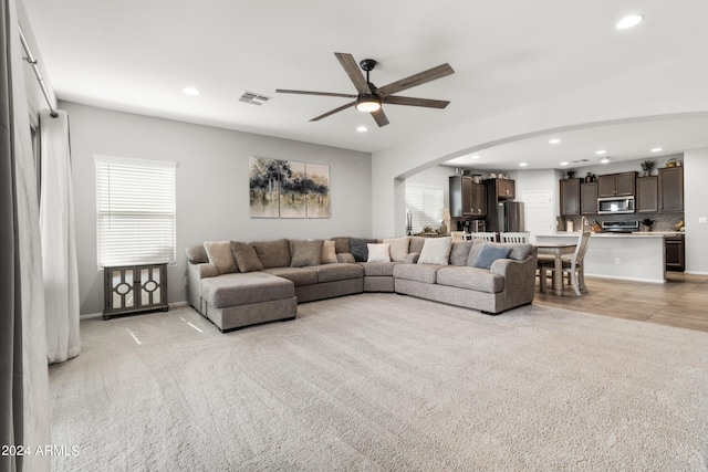 carpeted living room featuring ceiling fan