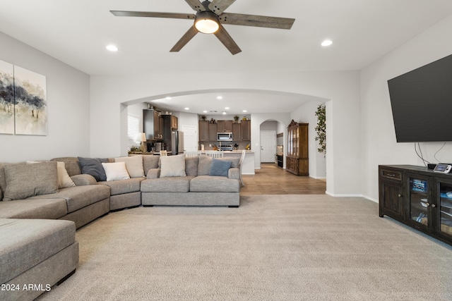 living room with light colored carpet and ceiling fan