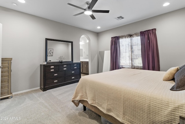 carpeted bedroom featuring ensuite bathroom and ceiling fan