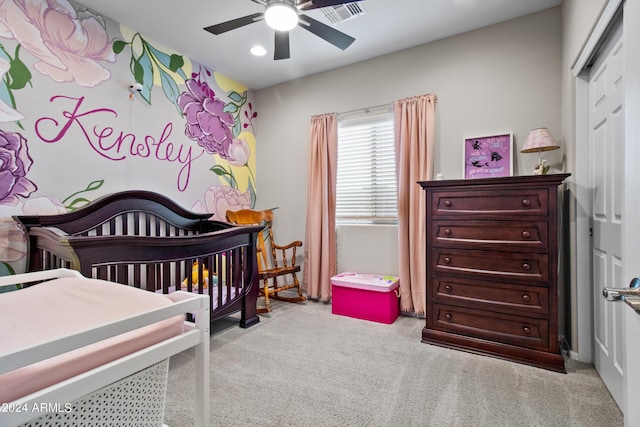 carpeted bedroom with a nursery area and ceiling fan