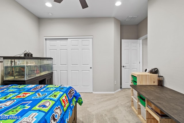 bedroom with light colored carpet, ceiling fan, and a closet