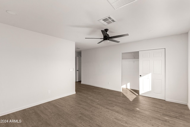 unfurnished bedroom featuring ceiling fan, dark hardwood / wood-style floors, and a closet