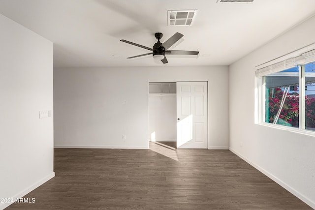 unfurnished bedroom featuring ceiling fan, a closet, and dark wood-type flooring