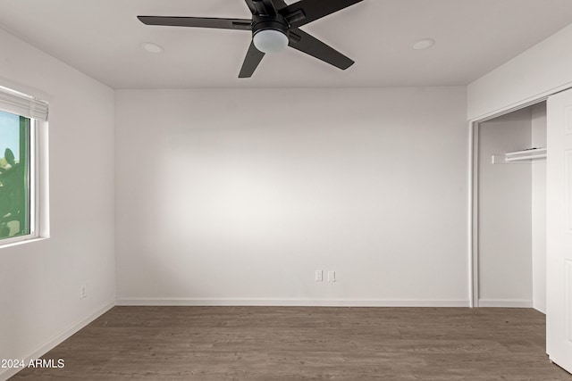 unfurnished bedroom featuring multiple windows, a closet, ceiling fan, and dark hardwood / wood-style floors