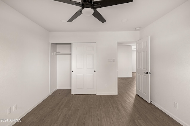 unfurnished bedroom with dark hardwood / wood-style flooring, a closet, and ceiling fan