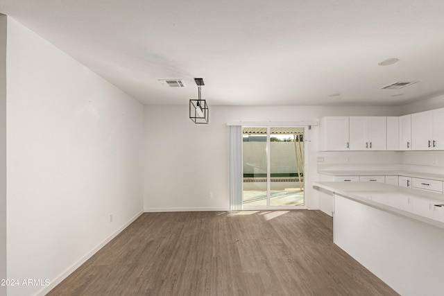 unfurnished dining area with dark wood-type flooring