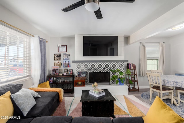 living room featuring ceiling fan, a fireplace, and hardwood / wood-style floors