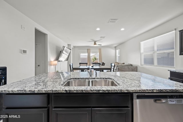 kitchen featuring visible vents, an island with sink, a sink, dishwasher, and open floor plan