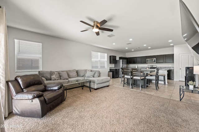 living room featuring visible vents, recessed lighting, light tile patterned floors, light colored carpet, and ceiling fan