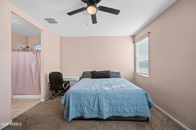 carpeted bedroom featuring tile patterned flooring, baseboards, visible vents, and ceiling fan