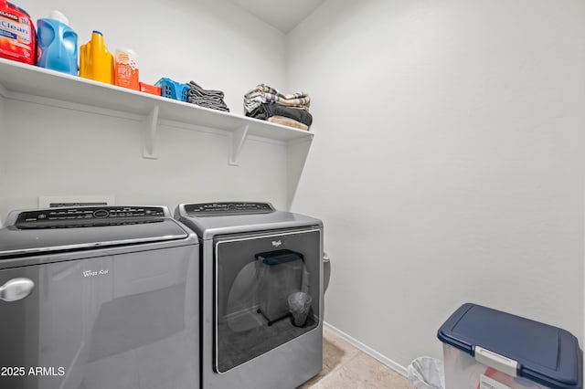 washroom with laundry area, washer and dryer, and baseboards