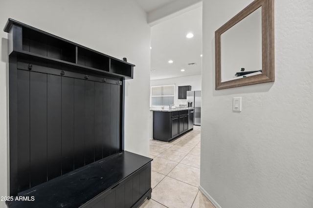 mudroom featuring light tile patterned floors, recessed lighting, visible vents, and a sink