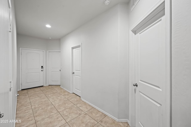 corridor with light tile patterned flooring, recessed lighting, and baseboards