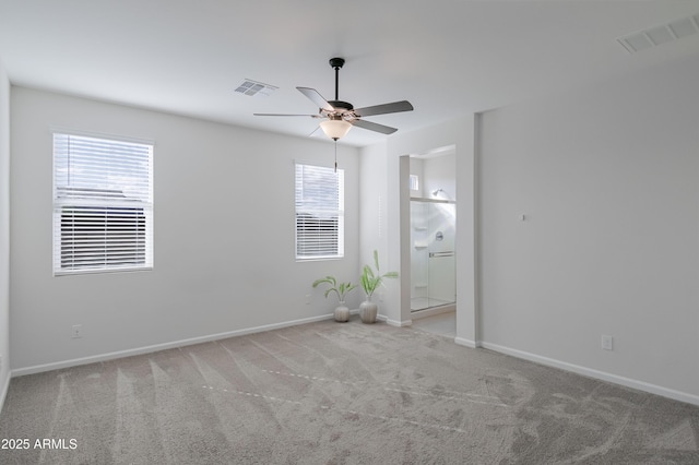 unfurnished room featuring carpet, visible vents, ceiling fan, and baseboards