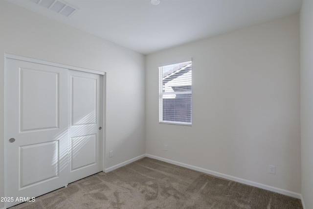 unfurnished bedroom featuring a closet, carpet flooring, and baseboards