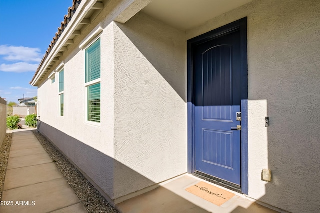 entrance to property featuring stucco siding