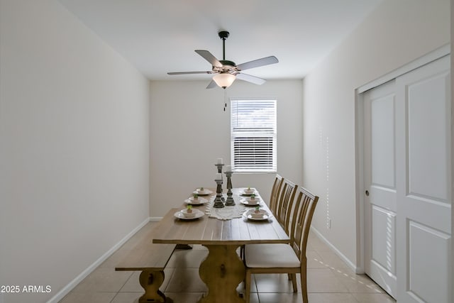 dining space featuring light tile patterned floors, a ceiling fan, and baseboards