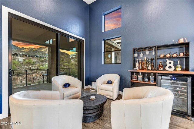 living room featuring a mountain view, hardwood / wood-style flooring, a towering ceiling, and ceiling fan