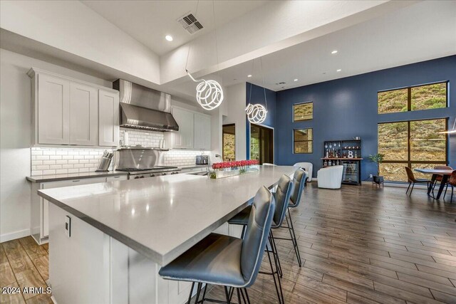 dining area with wine cooler, hardwood / wood-style floors, and a towering ceiling