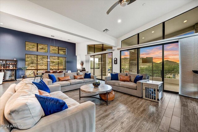 interior space featuring a towering ceiling, bar, beverage cooler, and dark wood-type flooring