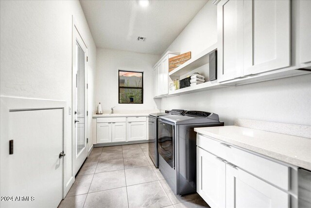 laundry room featuring cabinets, washer and dryer, light tile patterned flooring, and sink