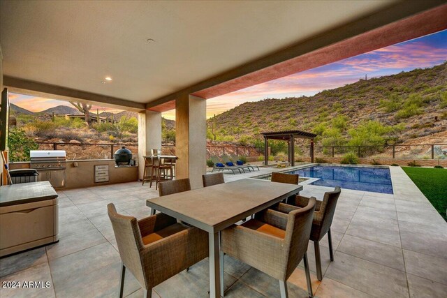 view of patio / terrace featuring a mountain view, grilling area, and a fenced in pool