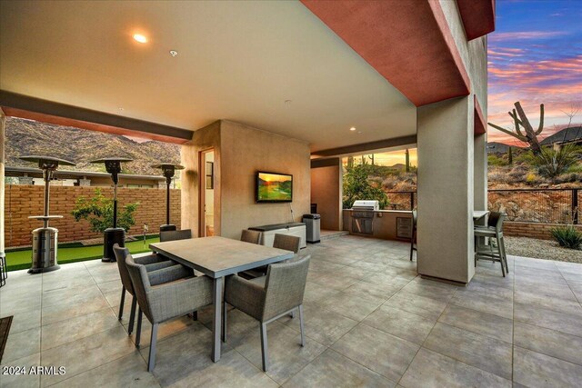 view of patio / terrace with a mountain view, exterior kitchen, a bar, and a grill