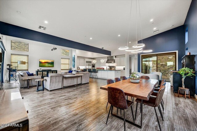 living room with high vaulted ceiling, a healthy amount of sunlight, and wood-type flooring