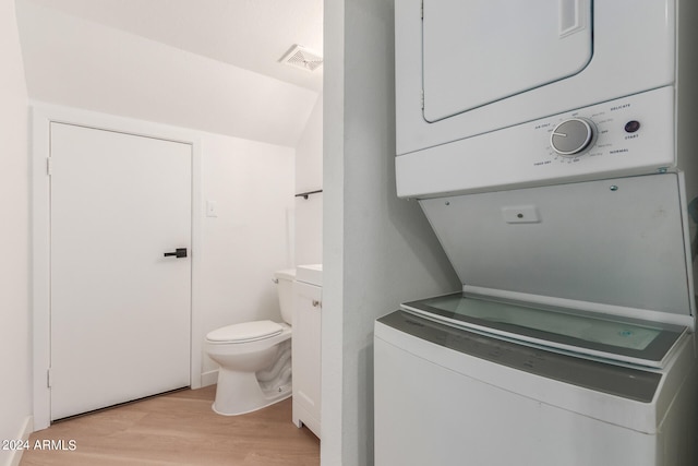 clothes washing area featuring stacked washer / dryer and light wood-type flooring