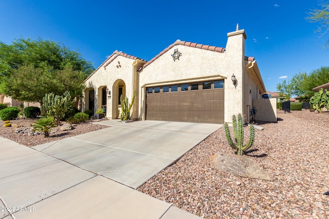 mediterranean / spanish-style home with a garage