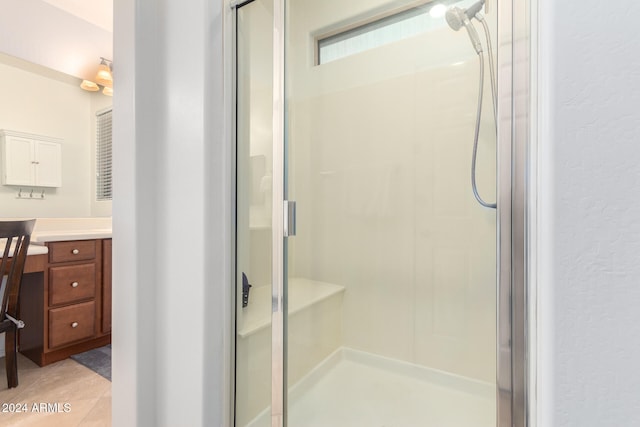 bathroom with vanity, walk in shower, and tile patterned flooring