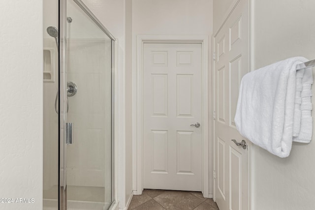 bathroom featuring a shower with door and tile patterned flooring