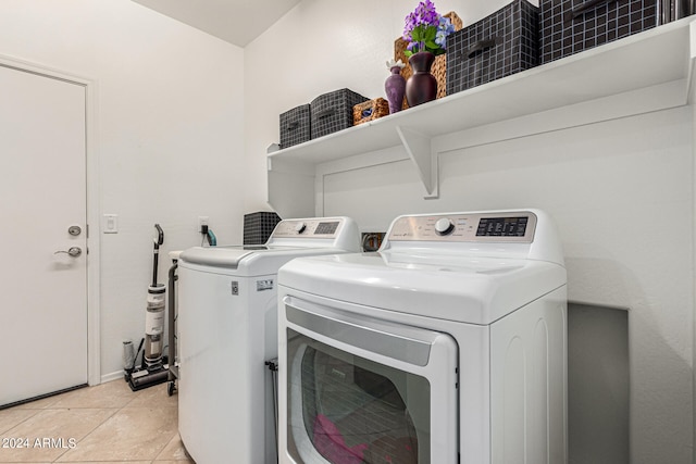 laundry area with washing machine and dryer and light tile patterned floors