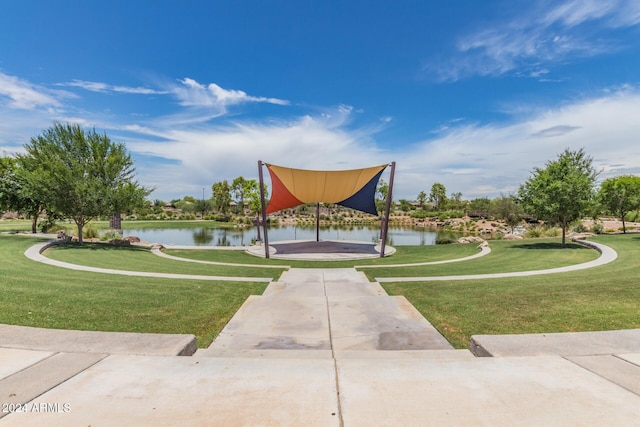 view of home's community with a lawn and a water view