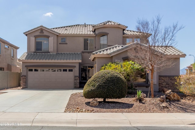 mediterranean / spanish-style house featuring an attached garage, a tile roof, stucco siding, stone siding, and driveway