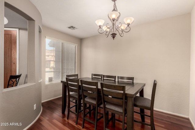 dining area featuring visible vents, baseboards, a notable chandelier, and dark wood-style floors