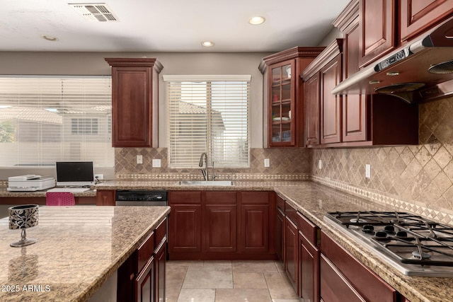 kitchen with visible vents, light stone countertops, under cabinet range hood, stainless steel appliances, and a sink