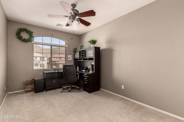 office area with ceiling fan, light colored carpet, visible vents, and baseboards