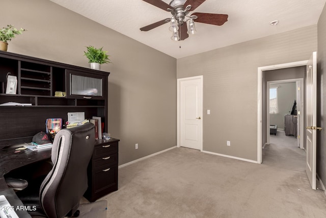 home office featuring a ceiling fan, light colored carpet, and baseboards